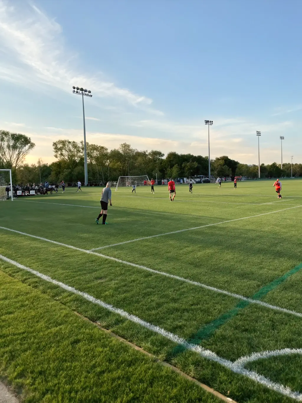 An image of a well-maintained sports field at ASSOCIATION PLAISANCE LOISIRS, with people playing a friendly game of soccer, emphasizing the association's commitment to sports and recreation.